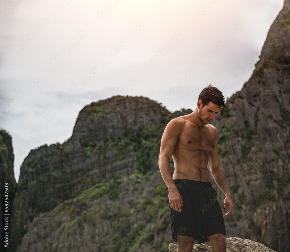 Handsome young man standing on a beach in Phuket Island, Thailand Handsome young man standing on a beach in Phuket Island, Thailand