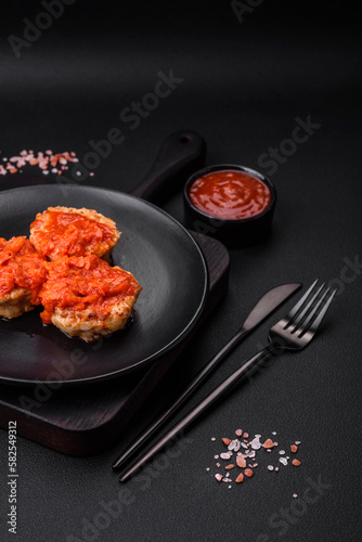 Delicious fresh cutlets or meatballs with spices, herbs and tomato sauce