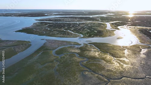 Landscape at sunset. Aerial view from a drone of the landscape of marshes and salt flats of the Ria Formosa Natural Park. Atlantic Ocean. Algarve. Portugal. Europe