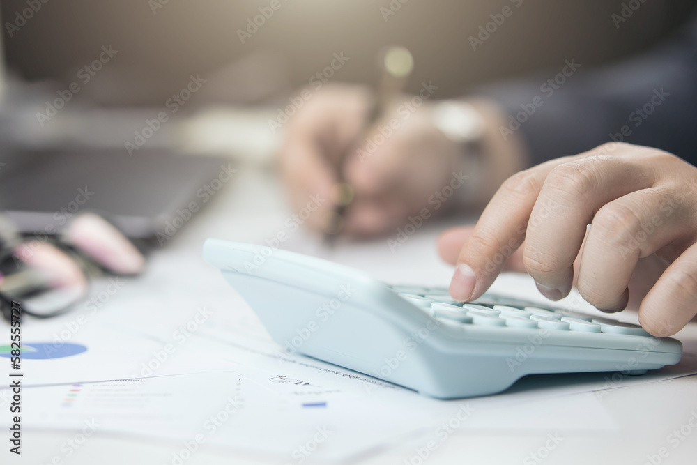 Male hand doing accounting, calculating bills, and expenses at home. Family budget bill payment checklist concept, pay bill check, income allocation plan, or Family budget hedge plan. Male hand doing accounting, calculating bills, and expenses at home. Family budget bill payment checklist concept, pay bill check, income allocation plan, or Family budget hedge plan.