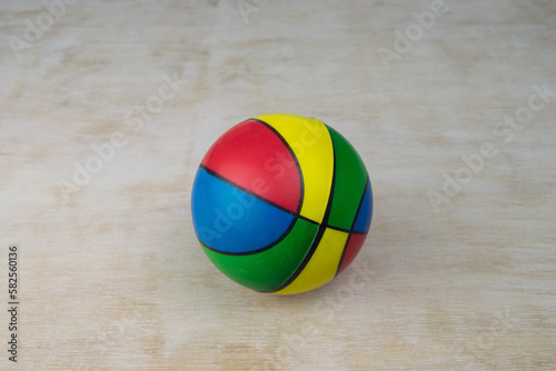 Toy basketball ball on a white wooden surface grain rubber bal. A toy on a white wooden board. Grain visible. Lots of copy space. Vintage look. 