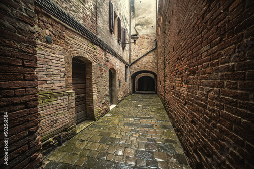 Narrow alley surrounded by stone walls in Buonconvento © Gabriele Maltinti