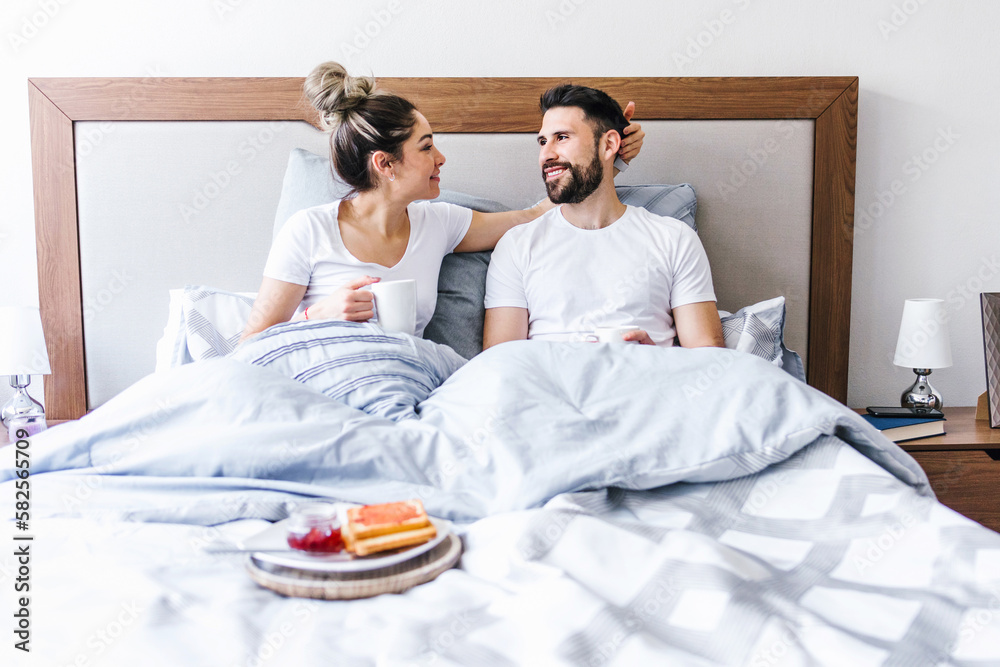 latin couple having breakfast in bed at home in Mexico, hispanic people