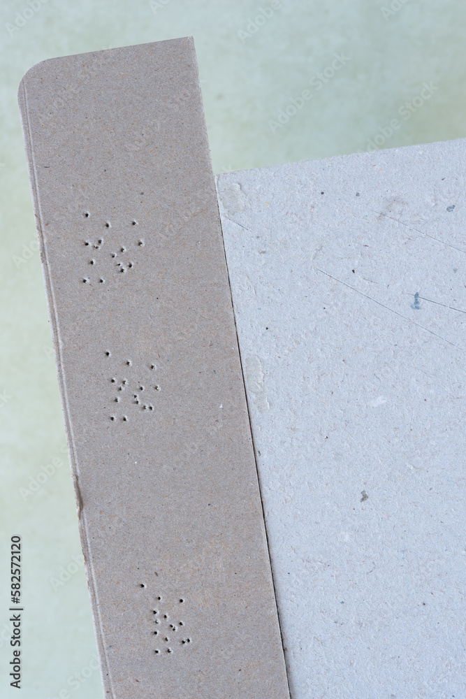 Fototapeta premium cardboard stripe with small puncture holes on a neutral background