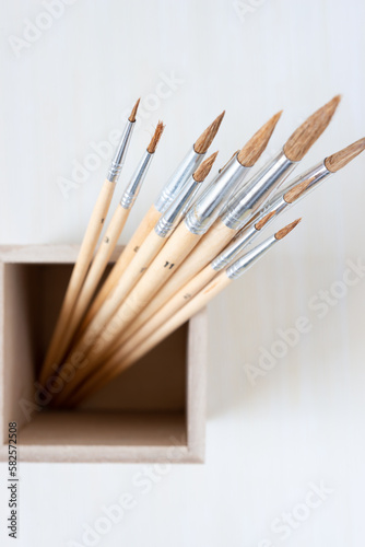 paint brushes in a wood box viewed from above