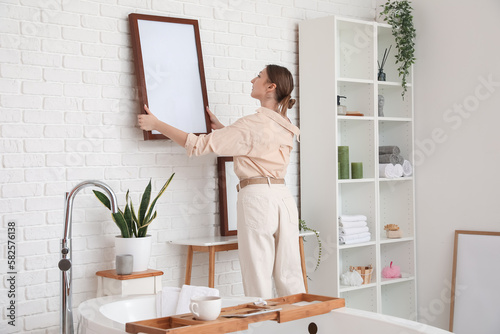 Young woman hanging blank f...