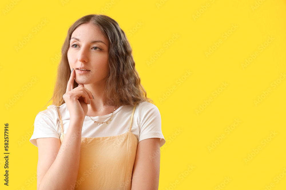 Thoughtful young woman on yellow background Thoughtful young woman on yellow background