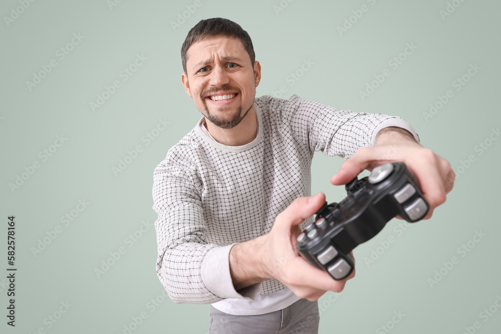 Handsome man with game pad on green background Handsome man with game pad on green background
