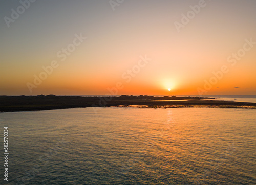 Beautiful warm sunrise view over the water and Lobos island in sunny Fuerteventura Spain  © Dave