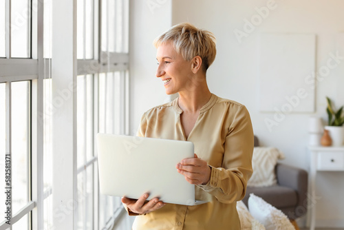 Mature woman with laptop at...