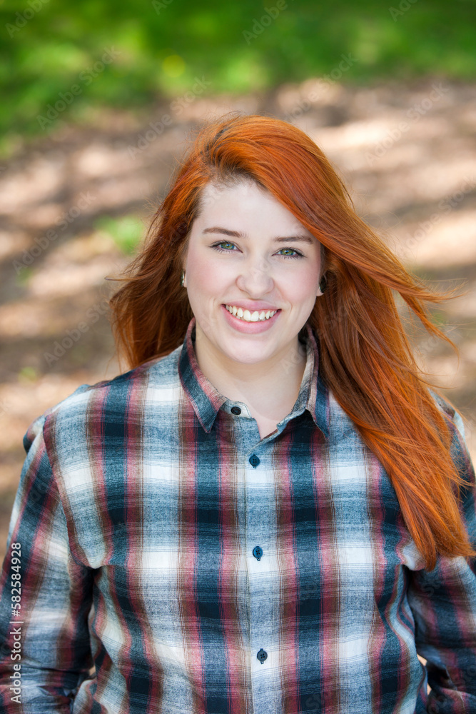 Outdoor portrait of young red haired woman.