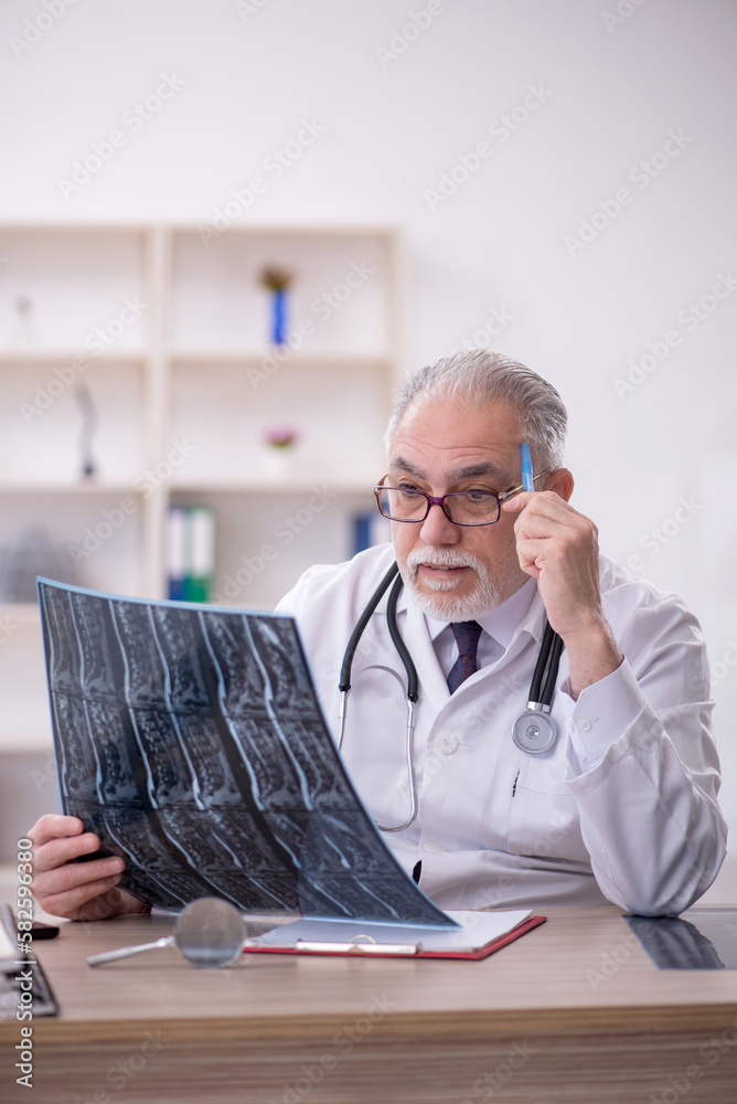 Old male doctor radiologist working in the clinic Old male doctor radiologist working in the clinic