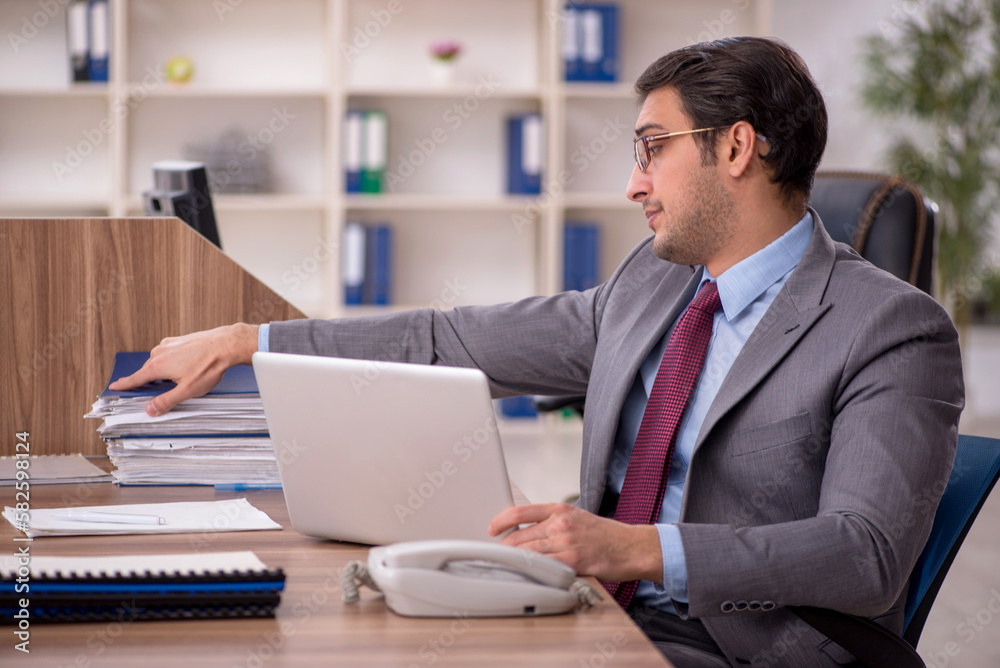 Young male employee working in the office Young male employee working in the office