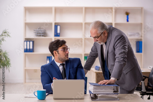 Old male boss and young male employee in the office © Elnur