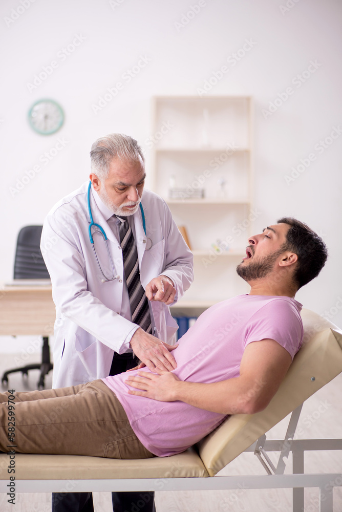 Young male patient visiting old male doctor Young male patient visiting old male doctor