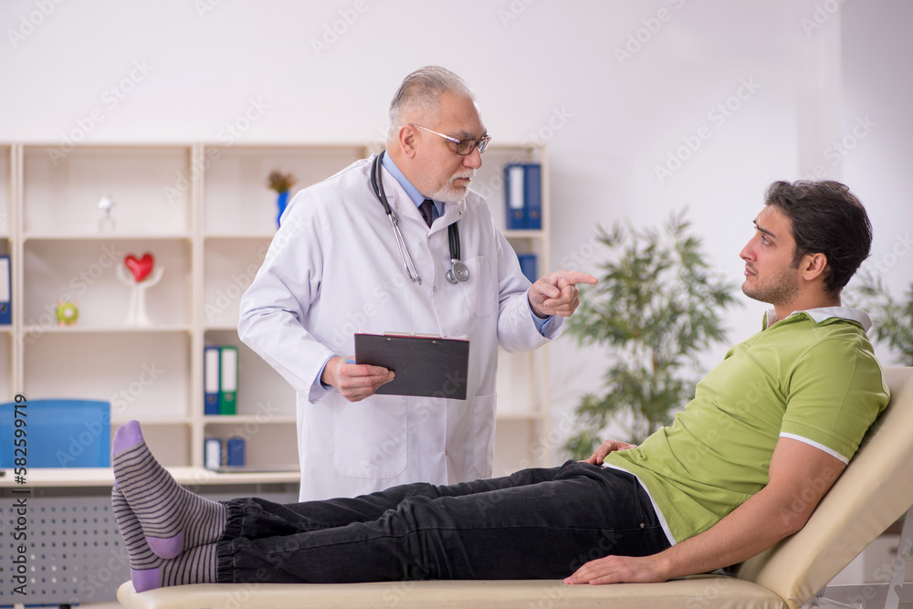 Young male patient visiting old male doctor Young male patient visiting old male doctor