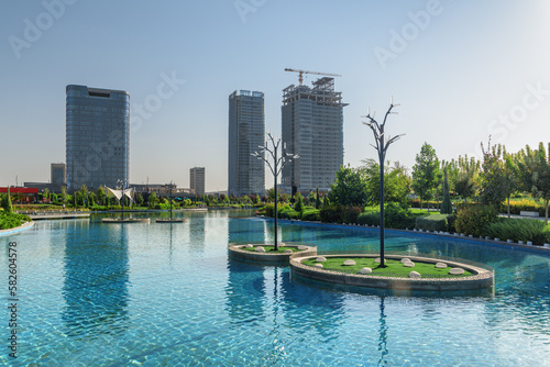 Contemporary buildings reflected in pool of Tashkent City Park