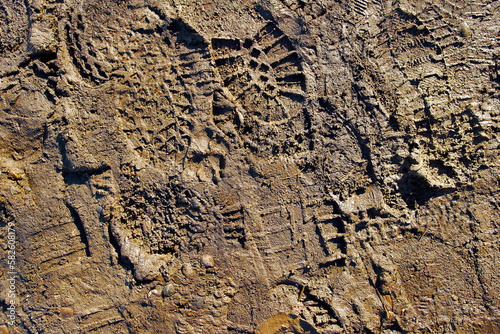 Wet ground with footprints. Mud ground with human footprints. Soil background