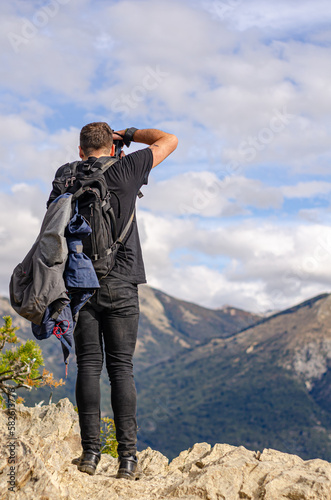 fotógrafo en la cima de una montaña sacando fotos del paisaje