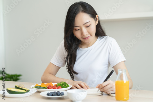 the person planning daily menu during dieting and writing diary to motivate.