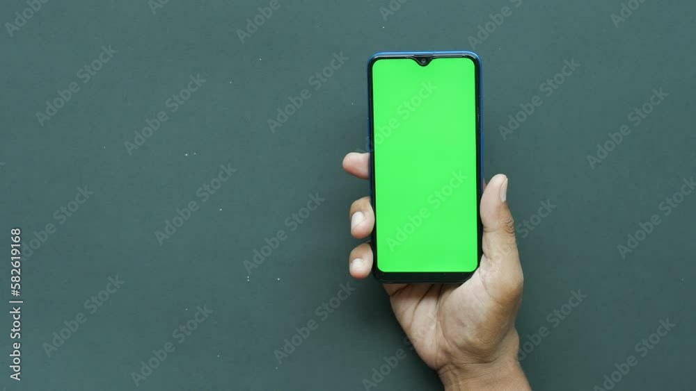 Close up of young man hand using smart phone with green screen Close up of young man hand using smart phone with green screen