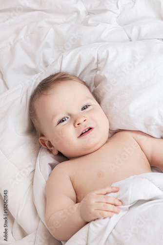 baby on a white blanket in a diaper