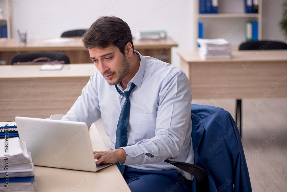 Young male employee working in the office Young male employee working in the office