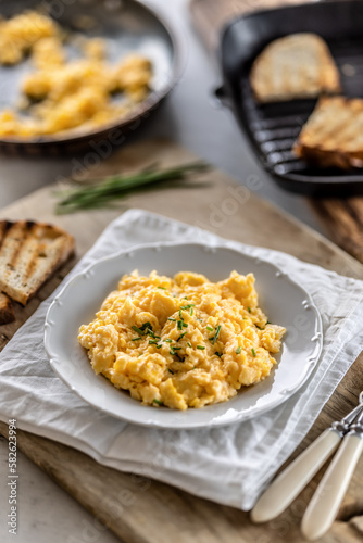 Silky-smooth scrambled eggs made to perfection and served in a plate for breakfast