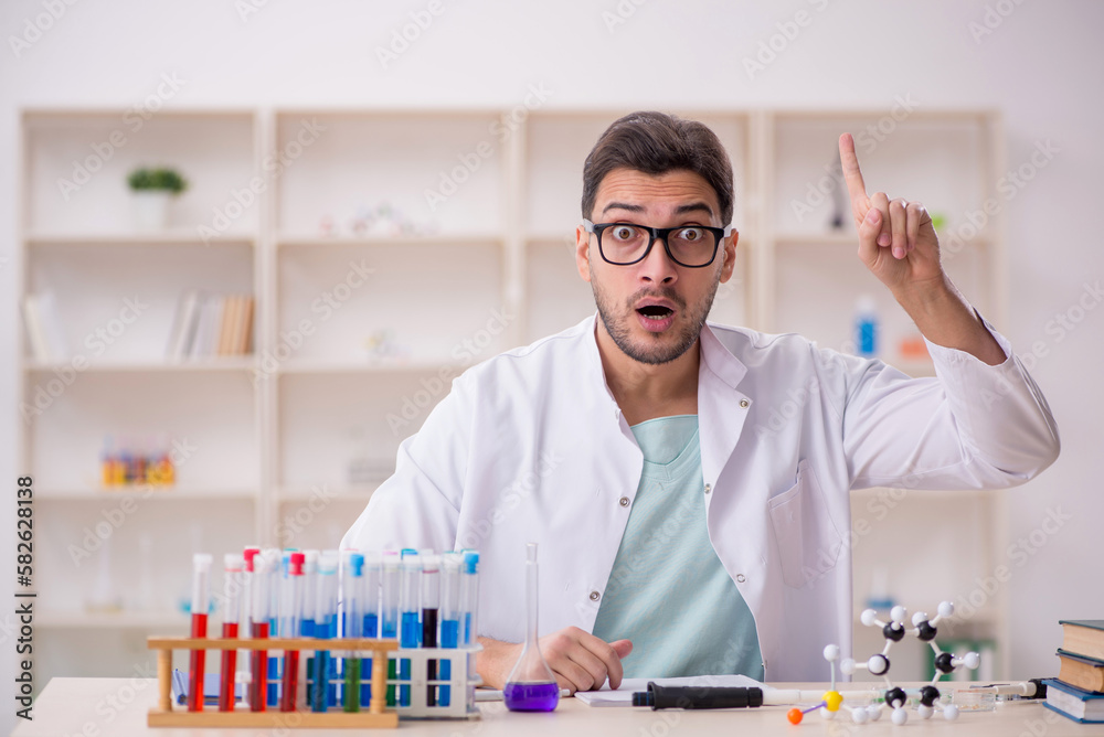 Young male chemist sitting at the lab Young male chemist sitting at the lab