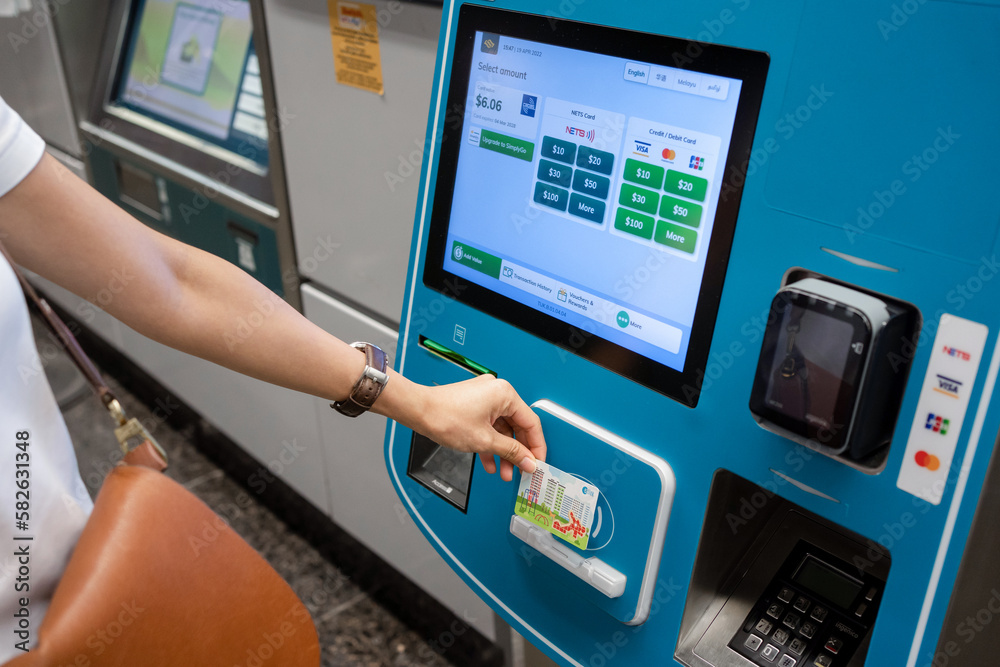 SINGAPORE APR 19, 2022 Lady's hand placing the Singapore MRT Card