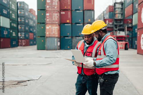 Foreman and the worker are checking the shipping container details.