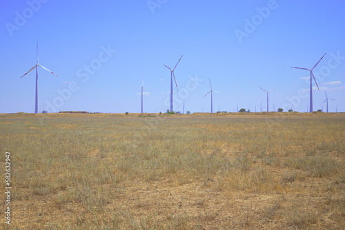 wind farm in the steppe against the blue sky © сергей тарануха