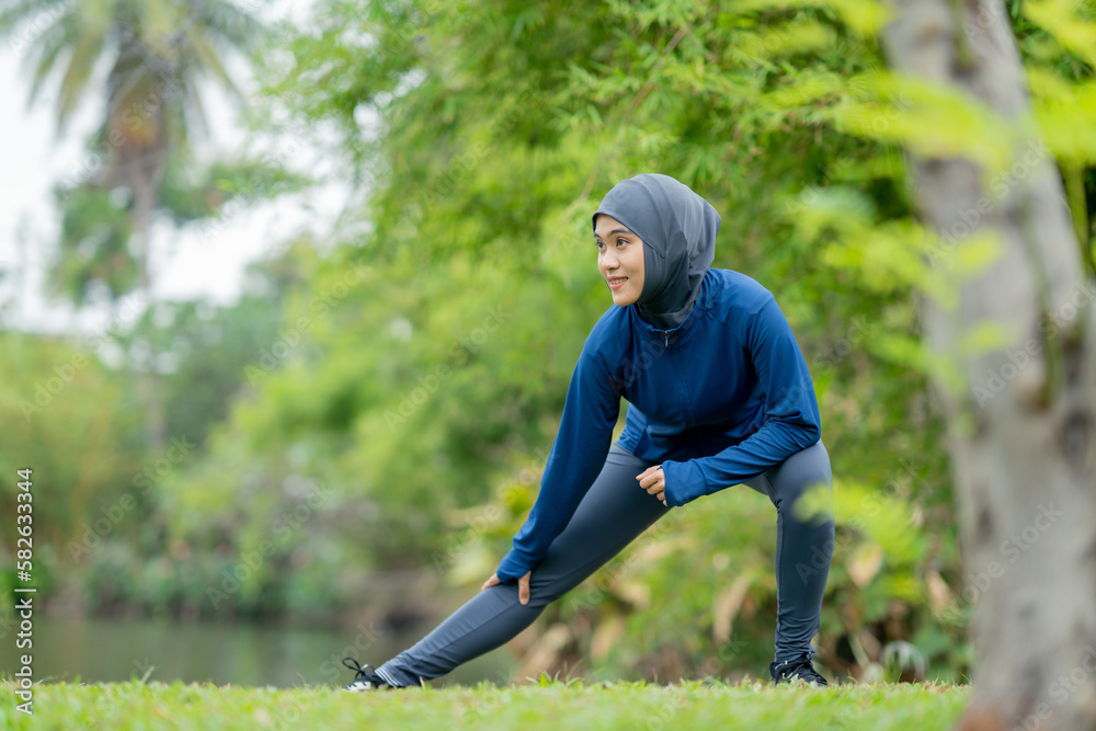 Asian cute muslim woman wearing sportswear and a blue hijab Exercising and running outdoors at the park in the morning. with a fresh feeling.