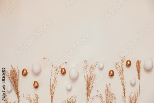 Top view of easter eggs colored with golden paint in differen patterns. White background. Copy space. photo