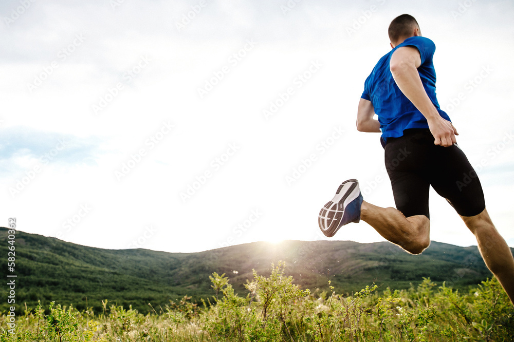 Obraz premium male runner running cross-country running race, colorful mountain plateau, summer sunset