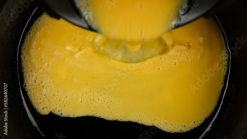 Pour mixed eggs in pan for cooking omelette, top view