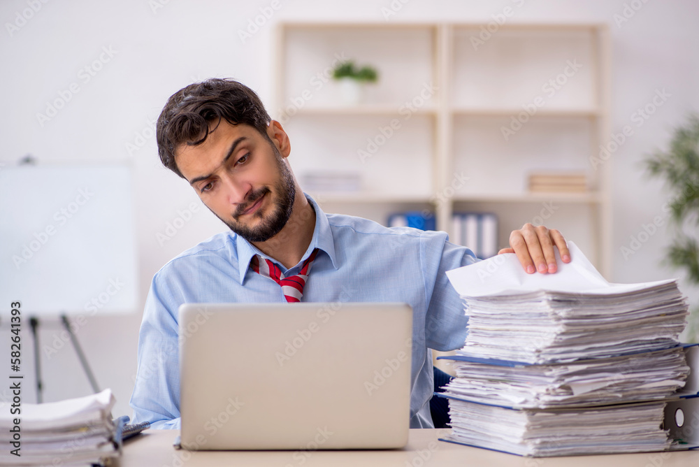 Young male employee working in the office Young male employee working in the office