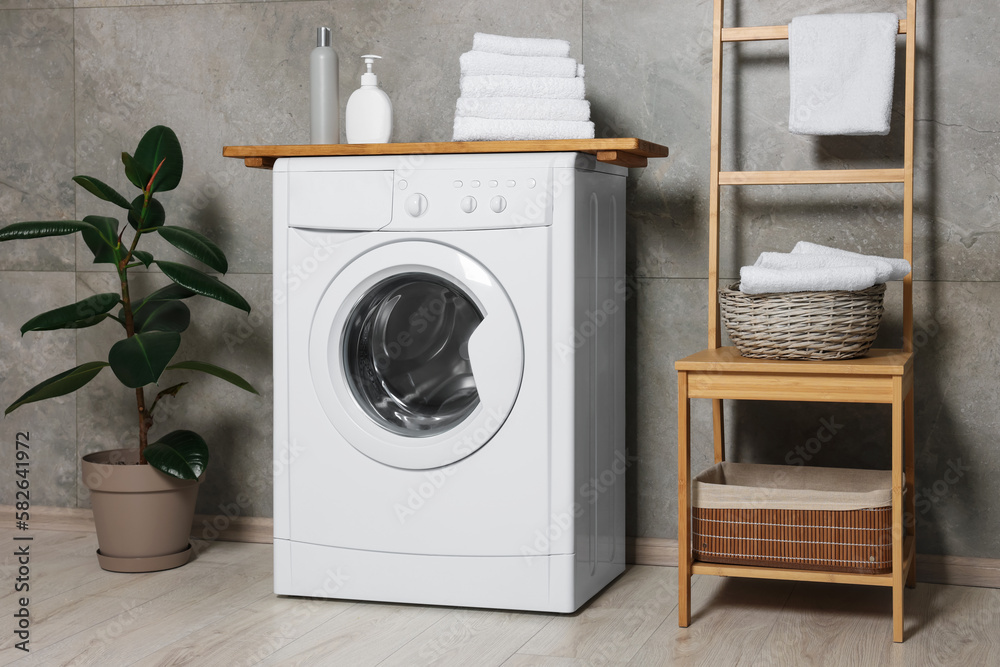 Stylish laundry room with modern washing machine. Interior design