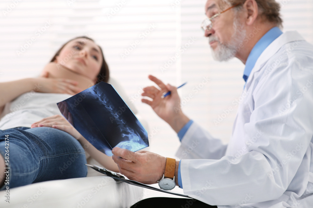 Orthopedist showing X-ray picture to patient in clinic Orthopedist showing X-ray picture to patient in clinic
