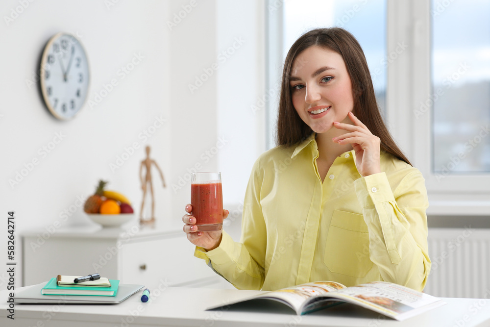 Beautiful young woman with delicious smoothie at table indoors Beautiful young woman with delicious smoothie at table indoors