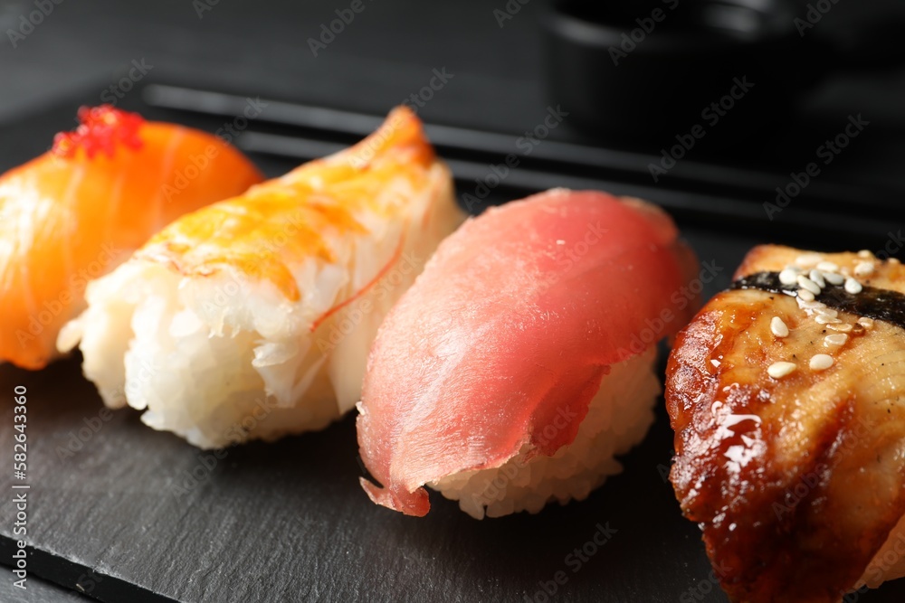 Plate with delicious nigiri sushi on black table, closeup Plate with delicious nigiri sushi on black table, closeup