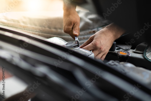 Auto mechanic worker checking and changing car battery. Car maintenance and auto service garage concept.