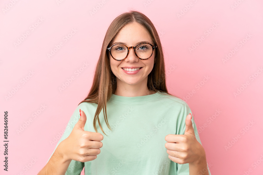 Young Lithuanian woman isolated on pink background With glasses and with thumb up Young Lithuanian woman isolated on pink background With glasses and with thumb up