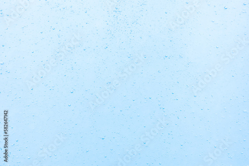 Close-up images of water bubbles or soda or liquid texture that splashing and floating up to surface like a explosion in blue color background