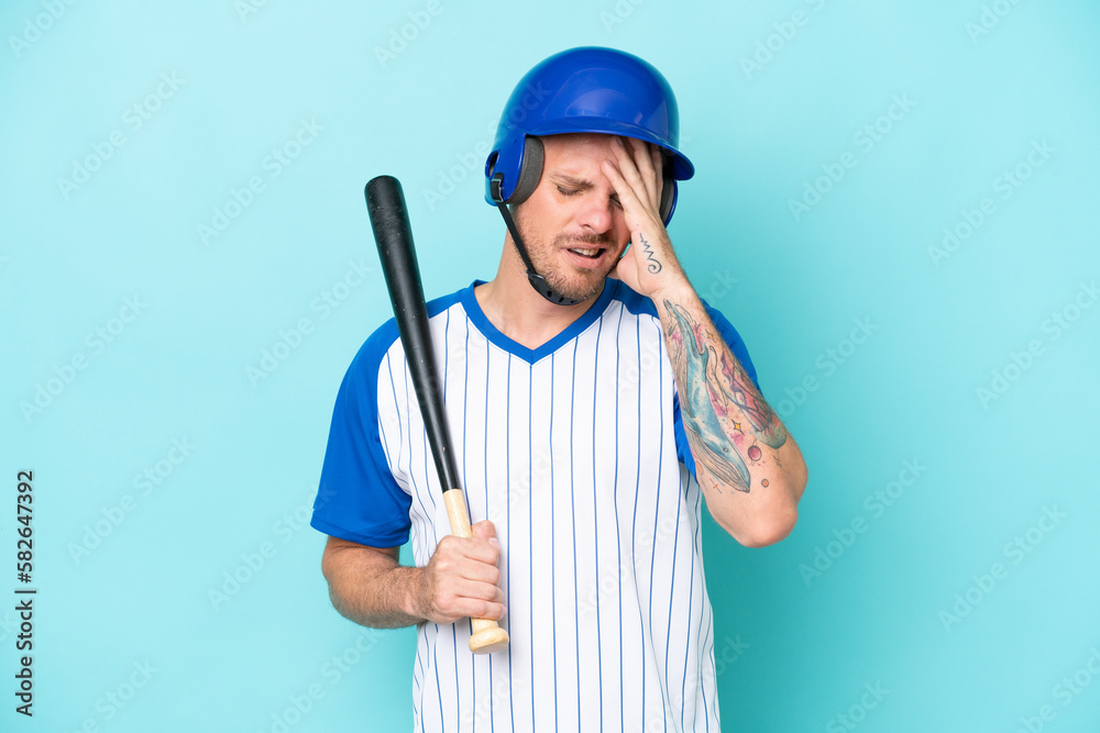 Baseball player with helmet and bat isolated on blue background with headache Baseball player with helmet and bat isolated on blue background with headache