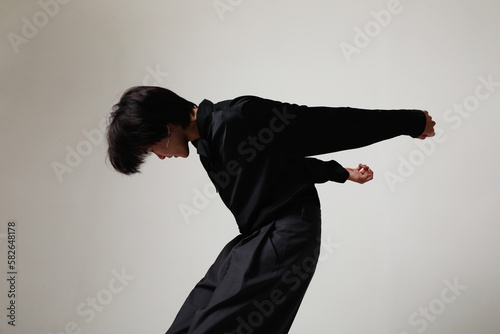 Confident young Asian man I'm moviment posing indoor over white background.  photo