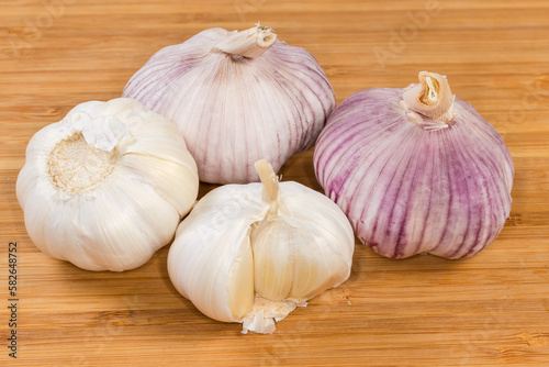 Bulbs of the garlic different varieties on a wooden surface