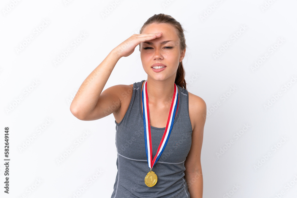 Young sport Russian girl with medals isolated on white background looking far away with hand to look something Young sport Russian girl with medals isolated on white background looking far away with hand to look something