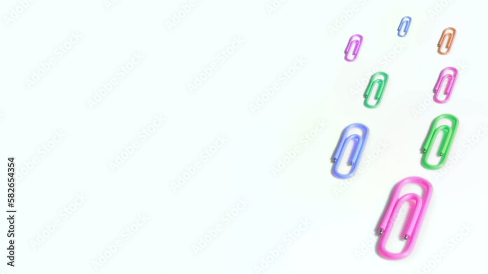 Colorful paper clips spin on white background Colorful paper clips spin on white background