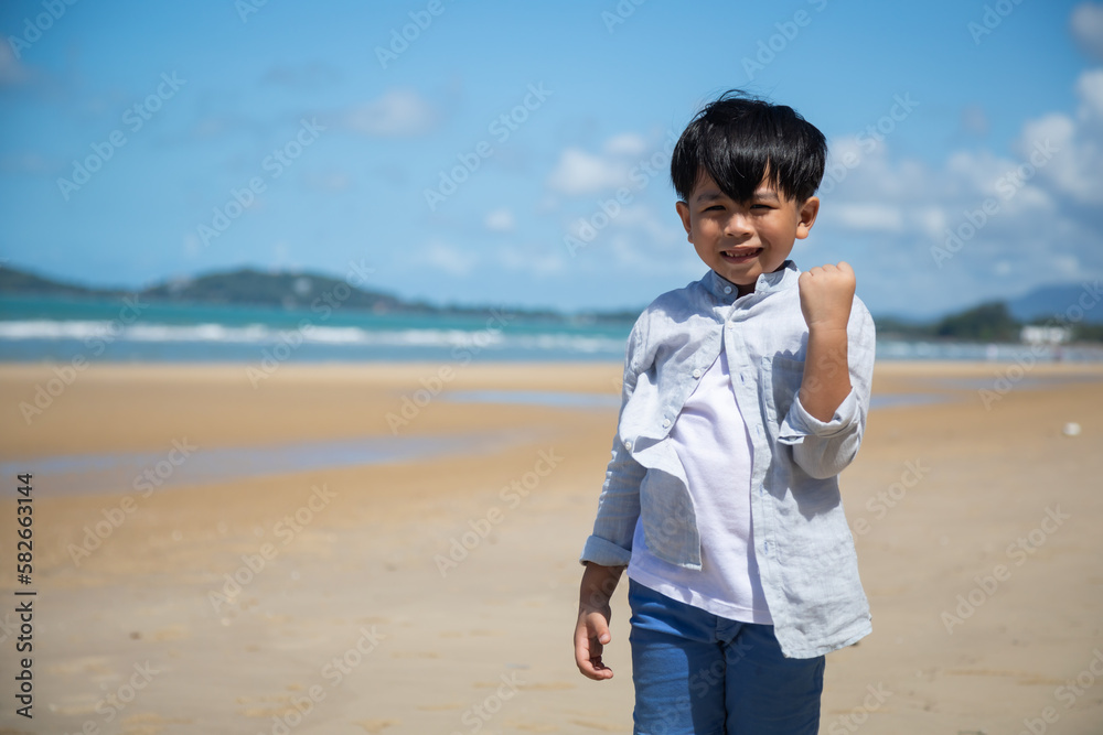 Happy summer holidays travel and vacation on the beach. Portrait Happy Asian kids boy looking at camera on sand beach Happy summer holidays travel and vacation on the beach. Portrait Happy Asian kids boy looking at camera on sand beach